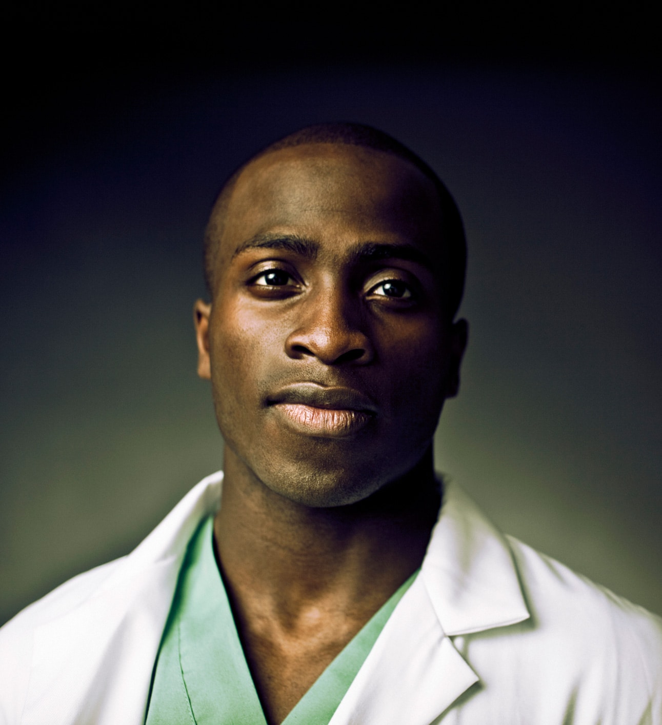 Photo of a Black doctor looking straight into the camera.