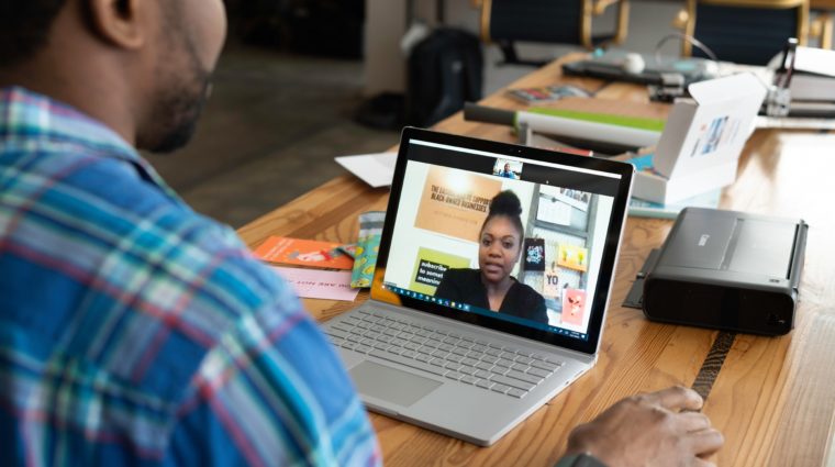Photo of a person speaking to another person on a laptop online