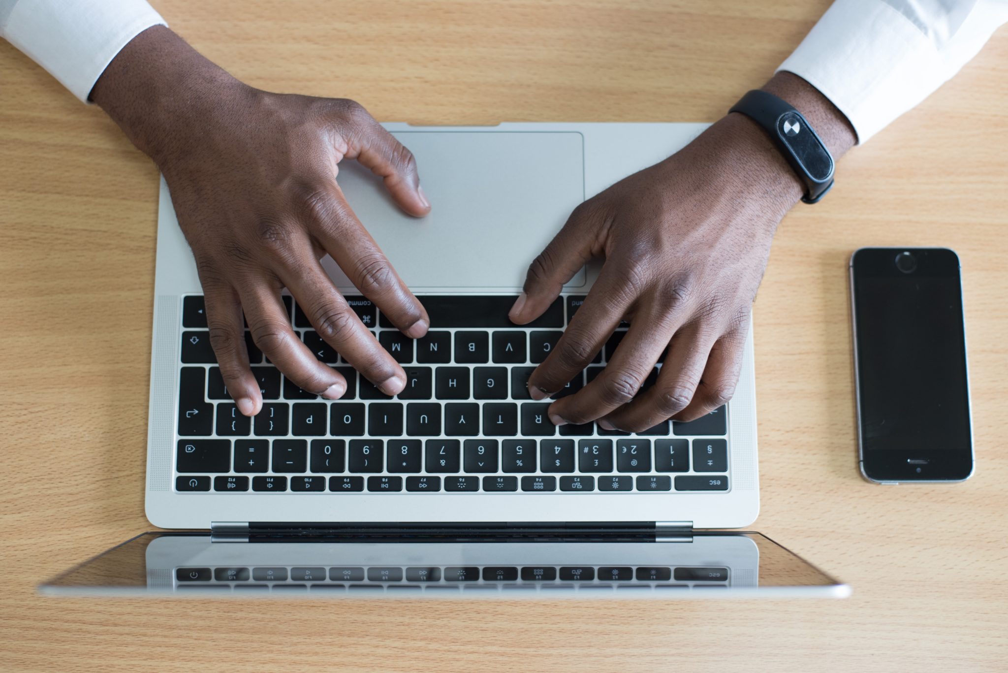 Photo of hands typing on a laptop keyboard