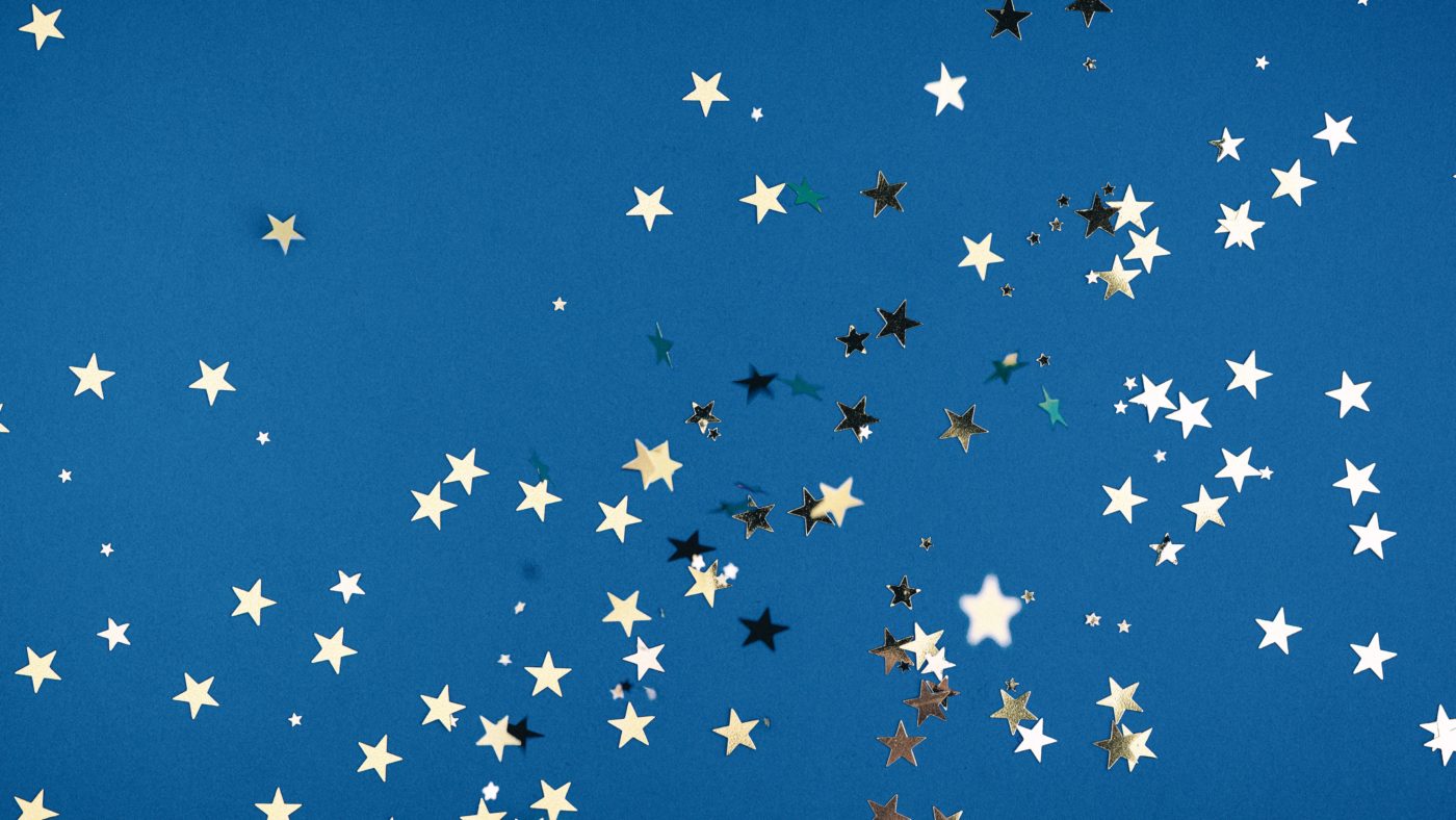 Photo of metallic stars floating against a blue background