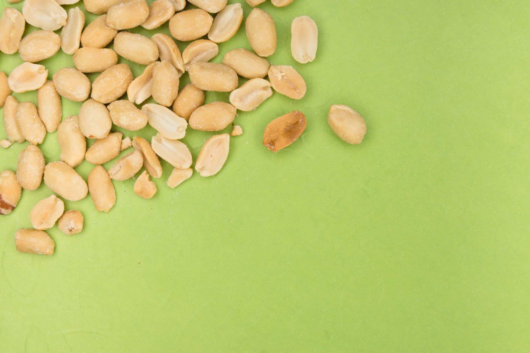 shelled peanuts on a bright green background