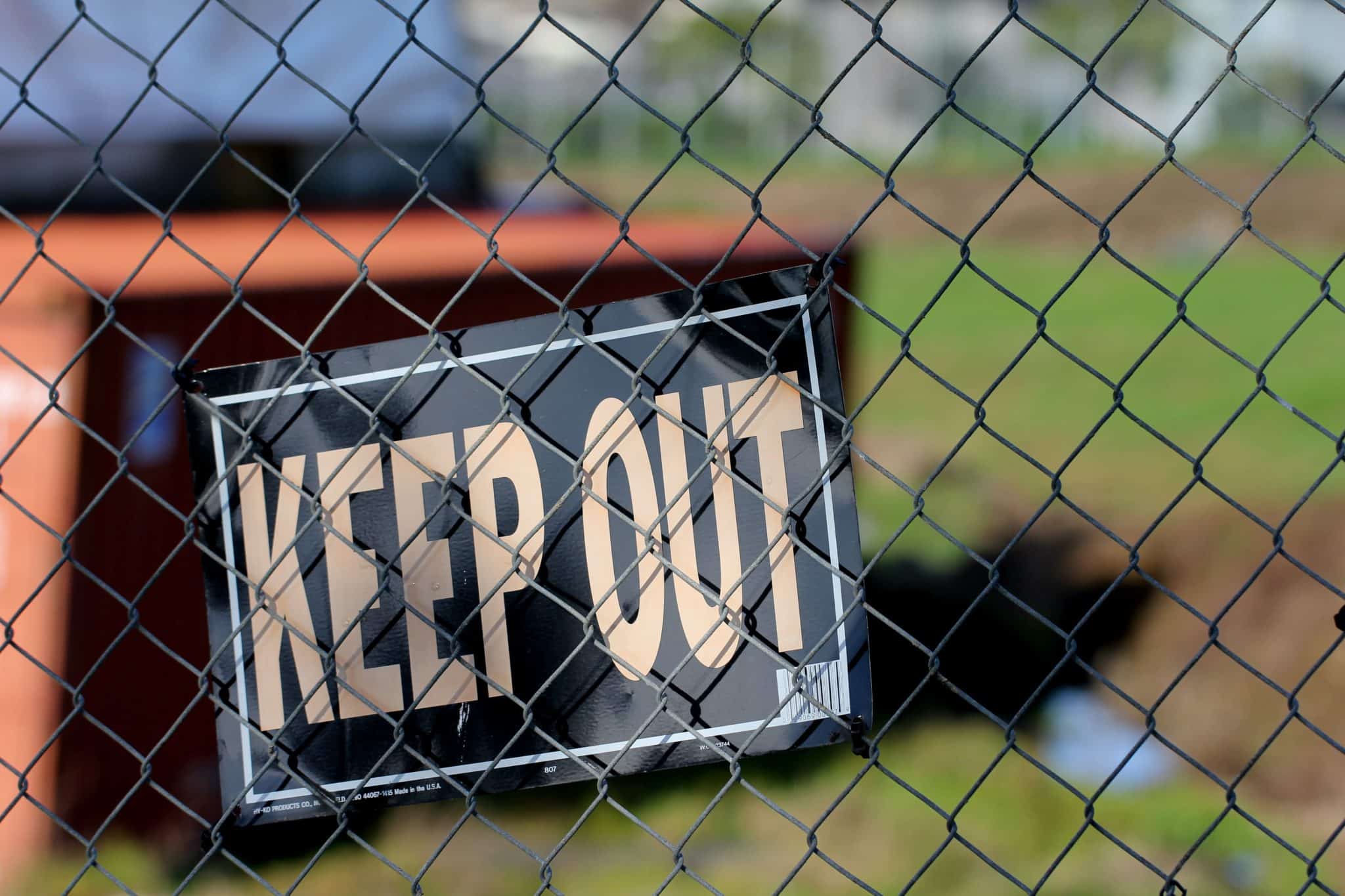 Sign reading "keep out" is attached to a wire fence