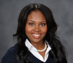 Headshot of NMF scholar Shanice Cox, wearing a black jacket, white blouse, and pearls