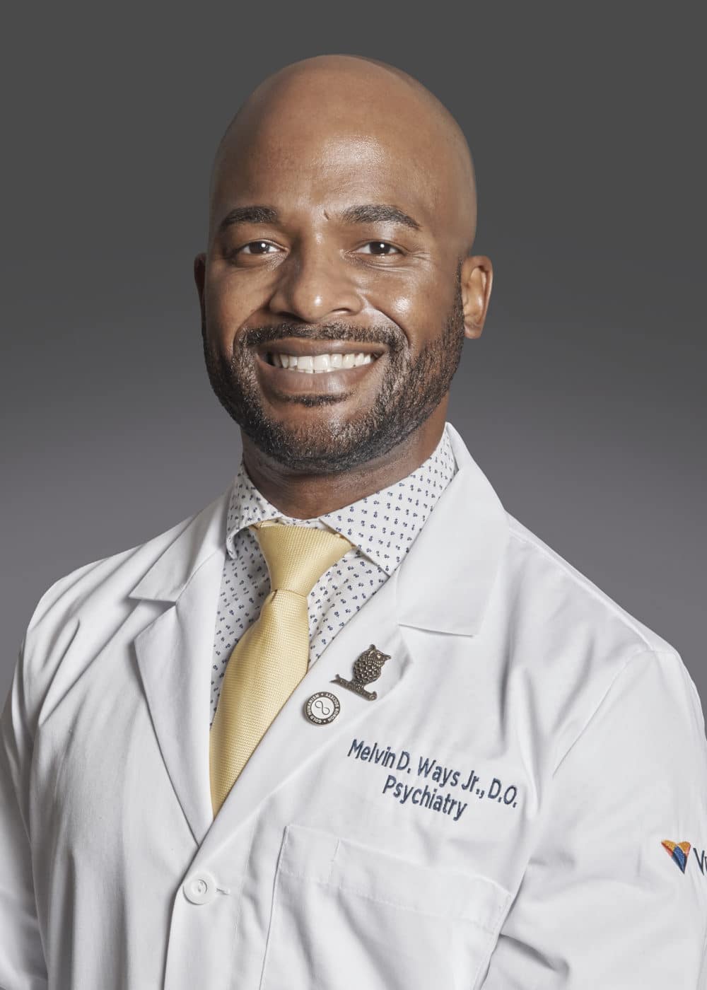 Photo of Dr. Melvin Ways wearing his doctor's white coat and a yellow tie.