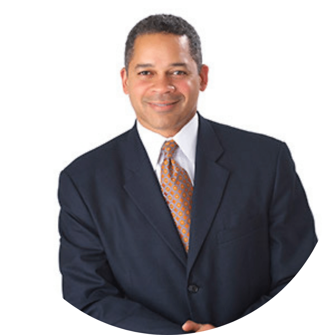Photo of Dr. Dallas Lea wearing a black jacket and tray and orange tie.