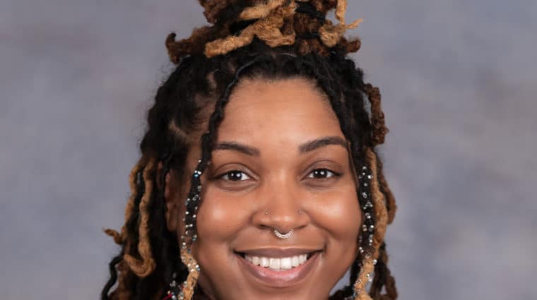 Headshot of Lauren Edwards, with braids in a bun, smiling into the camera