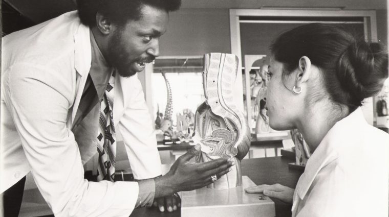 A photo of Dr. Lawrence Brown, Jr. working in a clinical setting with a colleague.