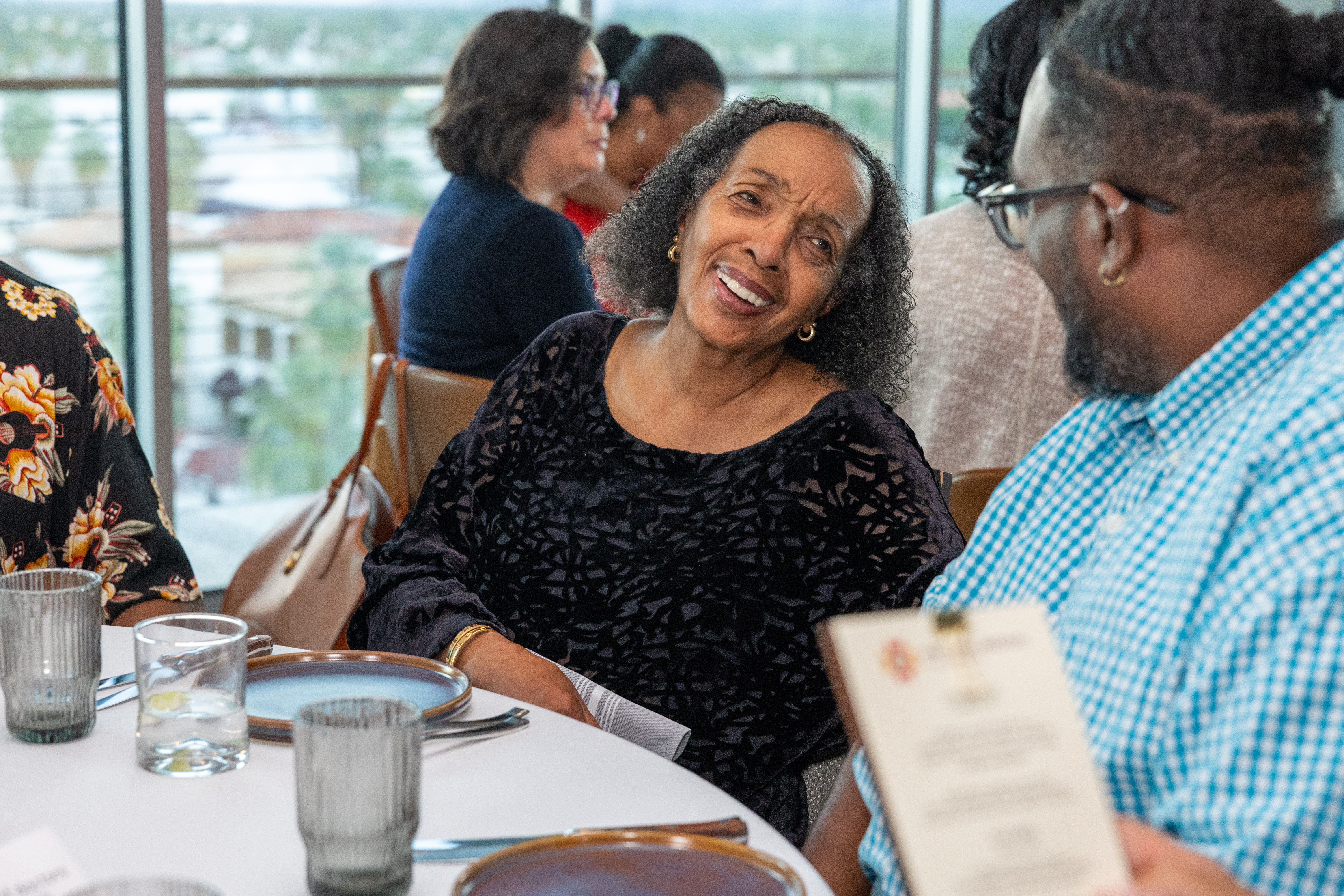 Photo of people engaged in lively conversation at tables