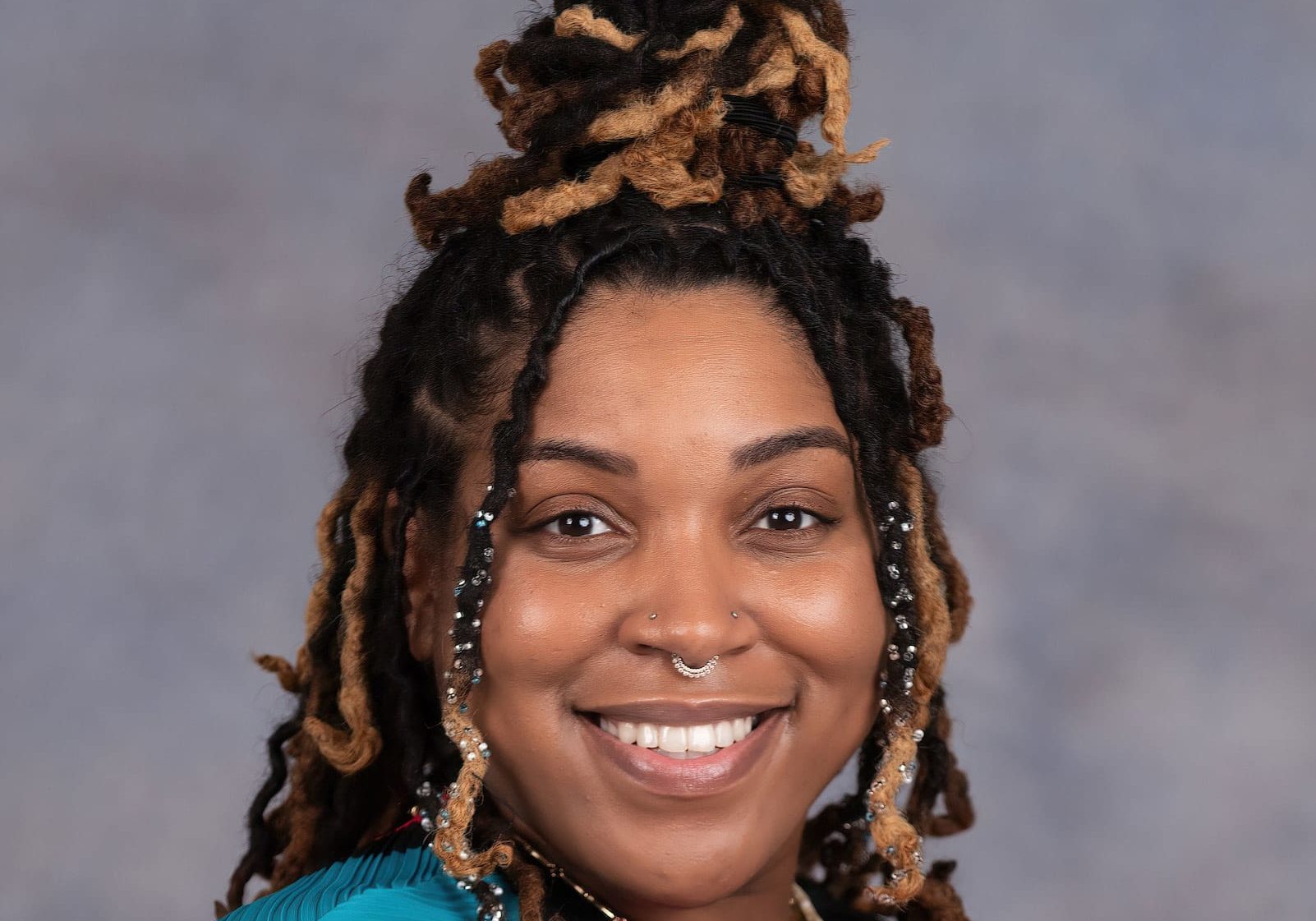 Headshot of Lauren Edwards, with braids in a bun, smiling into the camera