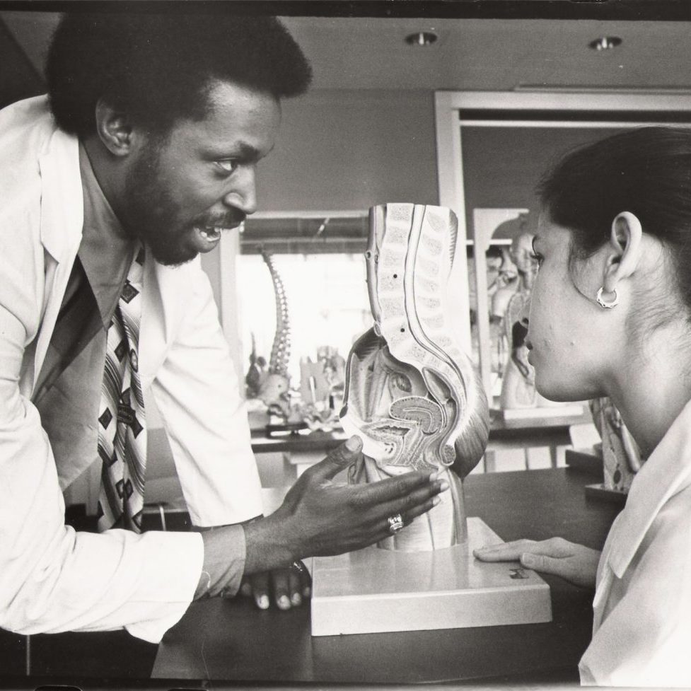 A photo of Dr. Lawrence Brown, Jr. working in a clinical setting with a colleague.
